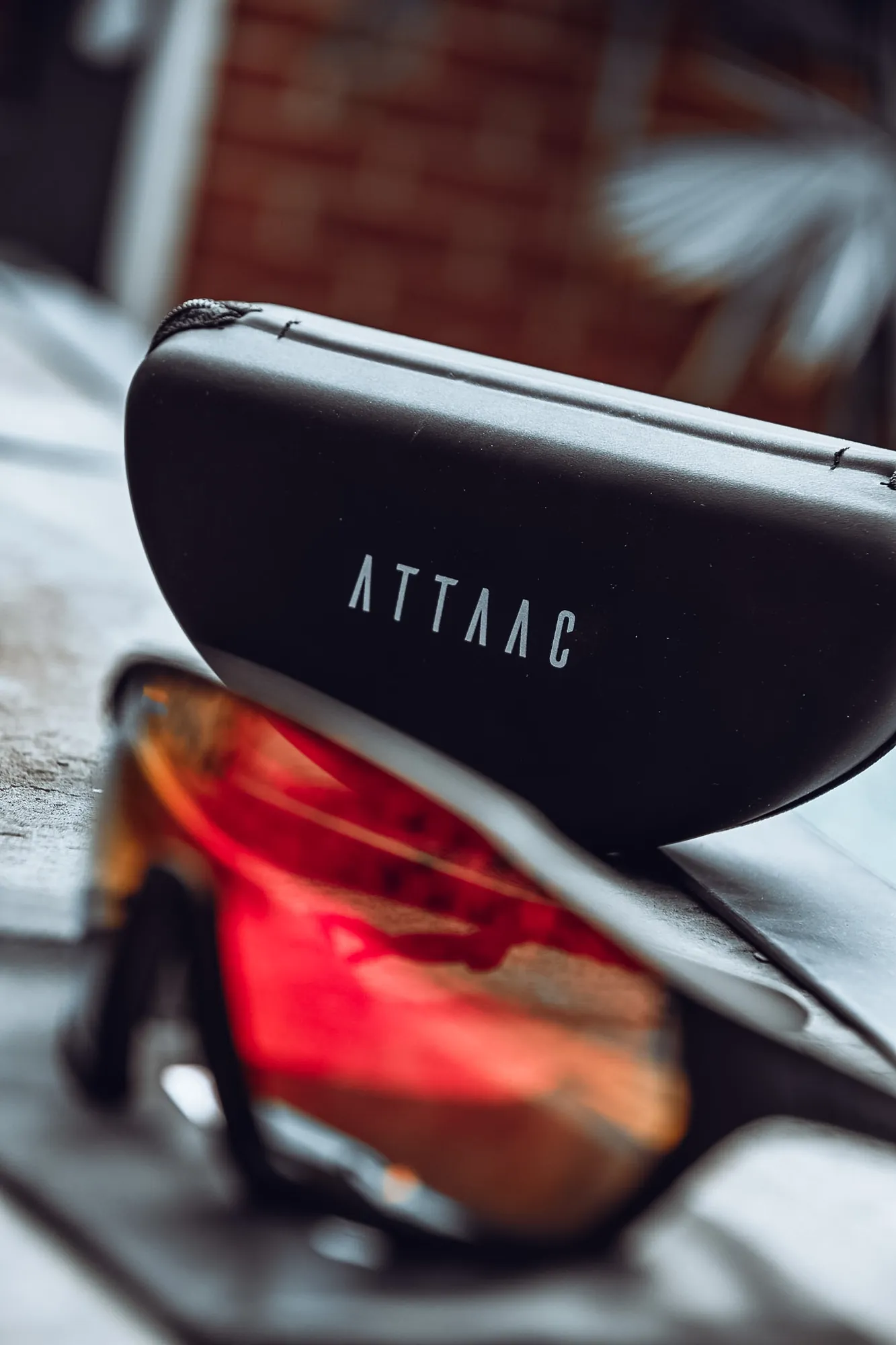ATTAAC-brillenkoker met een fietsbril met rode spiegelglazen op de voorgrond