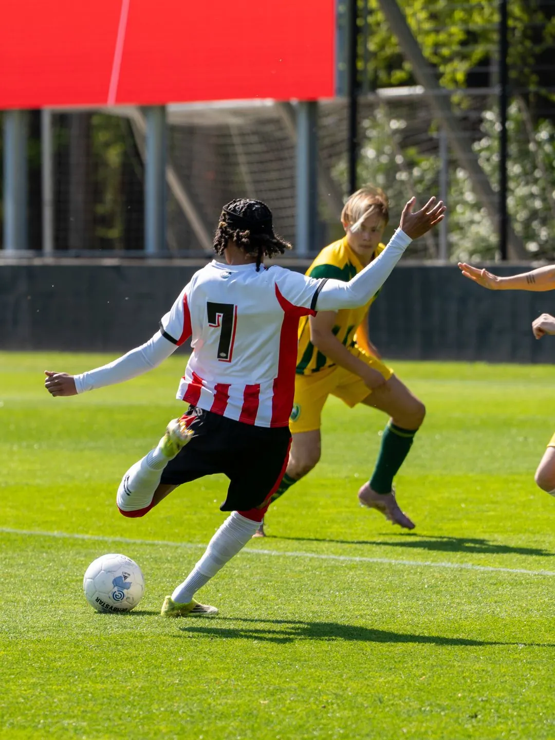 PSV-jeugdspeler met rugnummer 7 geeft een voorzet tijdens een wedstrijd