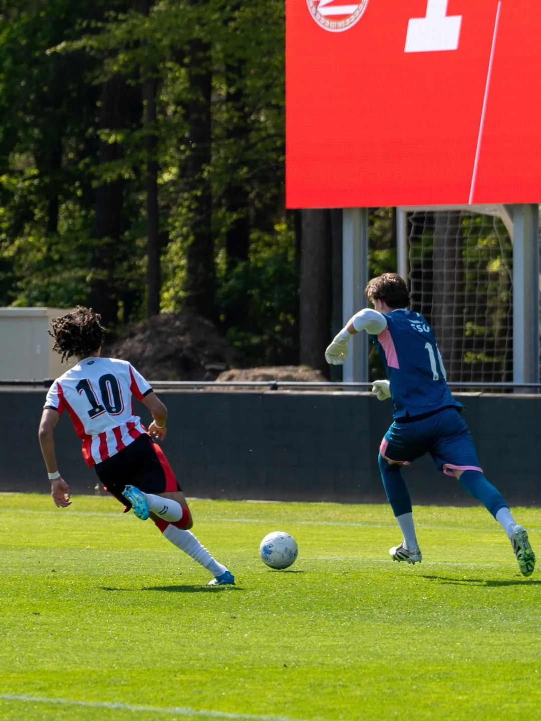 PSV-jeugdspeler met rugnummer 10 loopt met de bal op een verdediger af